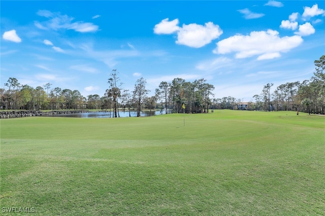 view of home's community featuring a water view, golf course view, and a lawn