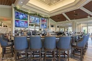 bar with coffered ceiling, a towering ceiling, and crown molding