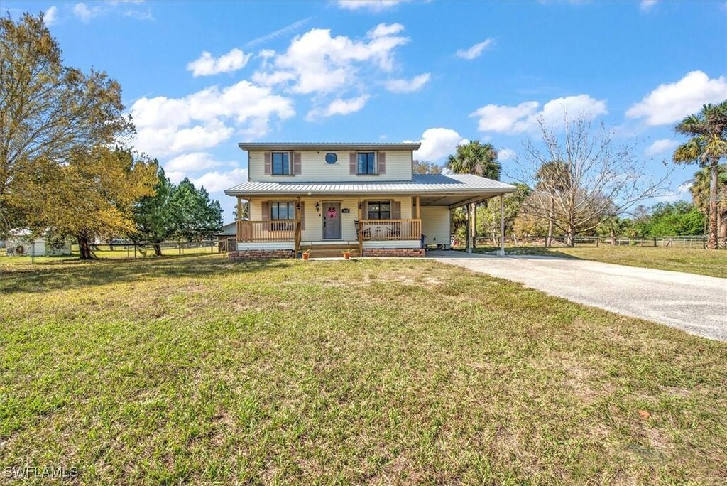 view of front of house with a porch, a carport, and a front yard
