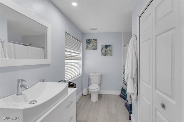 bathroom with sink, wood-type flooring, and toilet