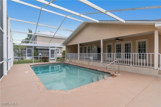 view of swimming pool with ceiling fan, a patio area, and glass enclosure