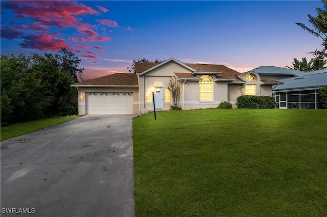 view of front facade with a garage and a lawn