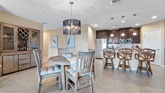 dining area with light tile patterned floors and an inviting chandelier