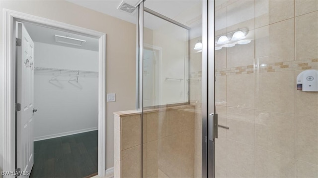 bathroom featuring hardwood / wood-style flooring and walk in shower