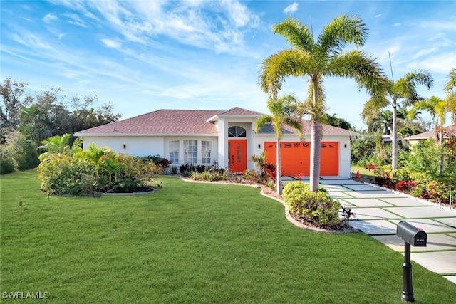 mediterranean / spanish home with a garage and a front lawn