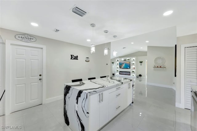 kitchen featuring vaulted ceiling, a kitchen island, decorative light fixtures, white cabinetry, and light tile patterned floors