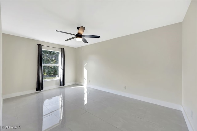 tiled empty room featuring ceiling fan