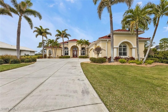 mediterranean / spanish home with a front yard