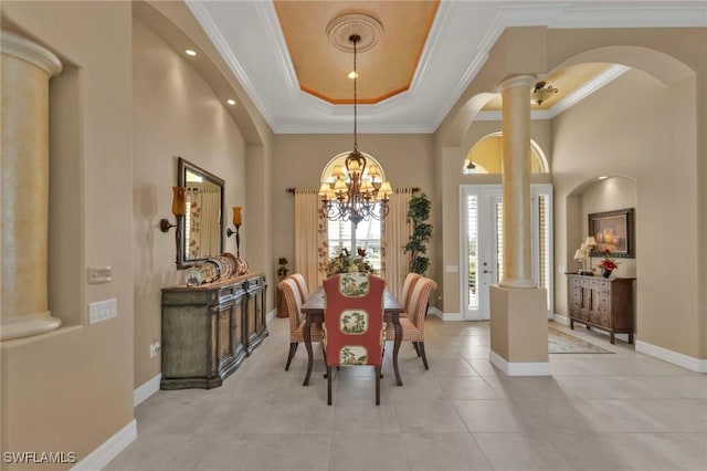 dining room with ornamental molding, decorative columns, a raised ceiling, and light tile patterned flooring