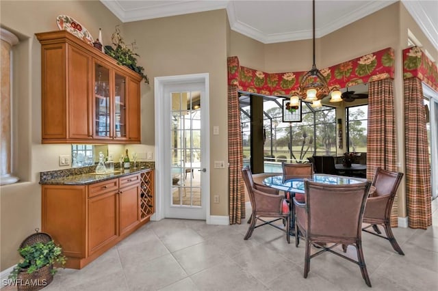 dining area featuring a notable chandelier, crown molding, and light tile patterned floors