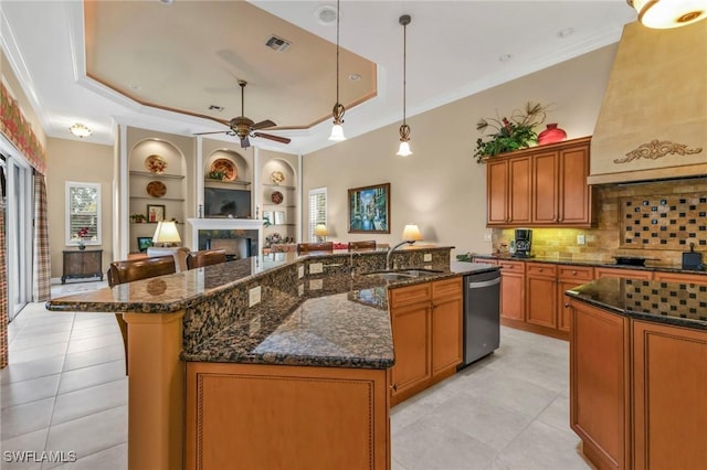 kitchen featuring sink, decorative light fixtures, ornamental molding, a tray ceiling, and a large island