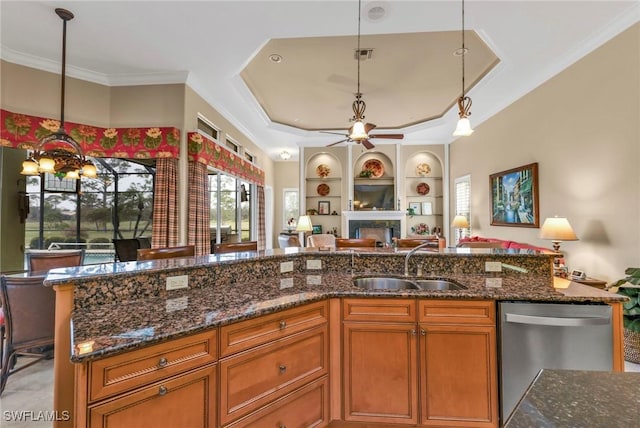 kitchen featuring hanging light fixtures, dishwasher, sink, and dark stone counters