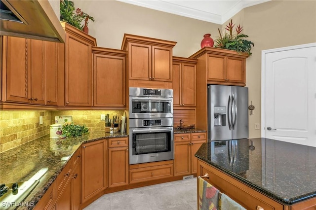 kitchen featuring premium range hood, dark stone countertops, appliances with stainless steel finishes, tasteful backsplash, and ornamental molding