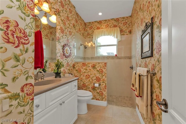 bathroom with tile patterned floors, vanity, toilet, and a tile shower