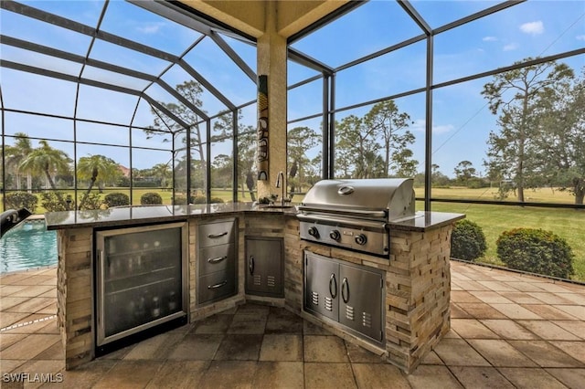 view of patio / terrace with area for grilling, beverage cooler, grilling area, and glass enclosure