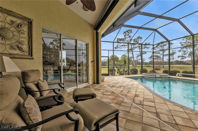 view of pool with a lanai, a patio area, ceiling fan, and an in ground hot tub