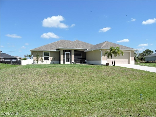 view of front of property featuring a garage, a front lawn, and a sunroom