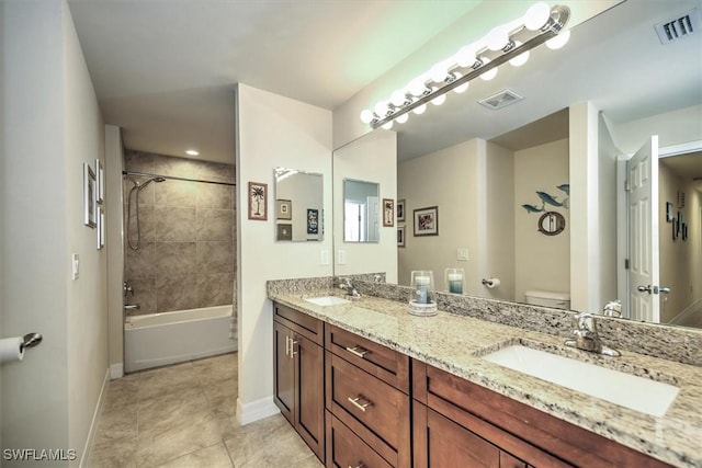 full bathroom with vanity, tile patterned flooring, tiled shower / bath combo, and toilet