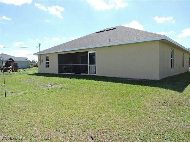 rear view of house with a yard and a playground