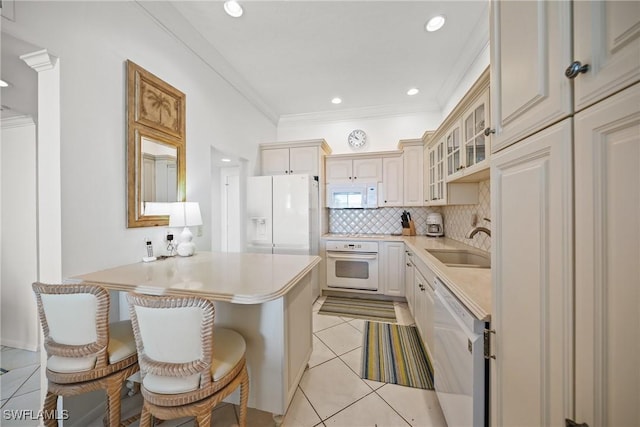 kitchen with white appliances, a sink, light countertops, backsplash, and crown molding