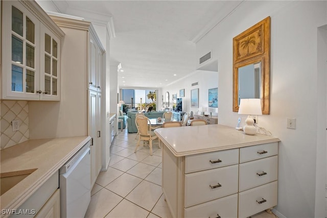 kitchen featuring dishwasher, backsplash, ornamental molding, light tile patterned flooring, and kitchen peninsula