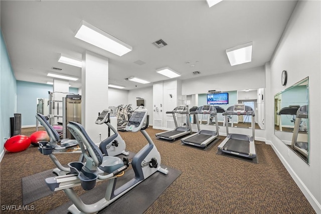 exercise room with visible vents and baseboards