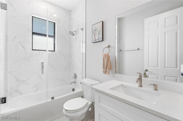 full bathroom featuring vanity, combined bath / shower with glass door, and toilet