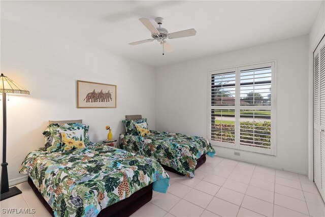 bedroom featuring light tile patterned floors, ceiling fan, and a closet