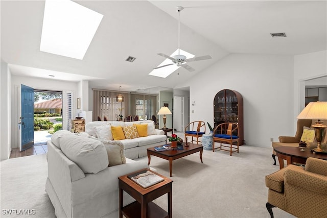 living room featuring high vaulted ceiling, a skylight, light colored carpet, and ceiling fan