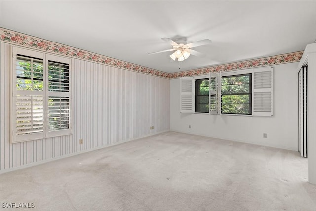 unfurnished room featuring ceiling fan and light carpet