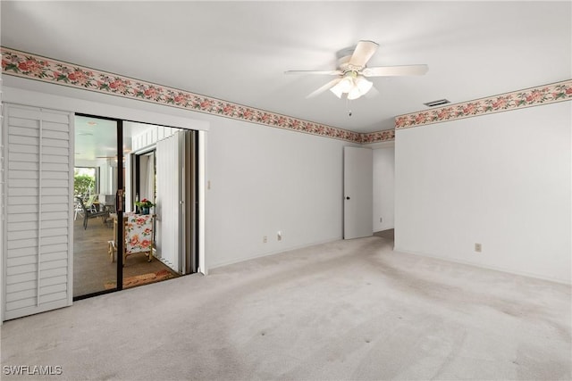 carpeted spare room featuring ceiling fan