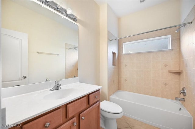 full bathroom featuring tiled shower / bath, vanity, toilet, and tile patterned floors