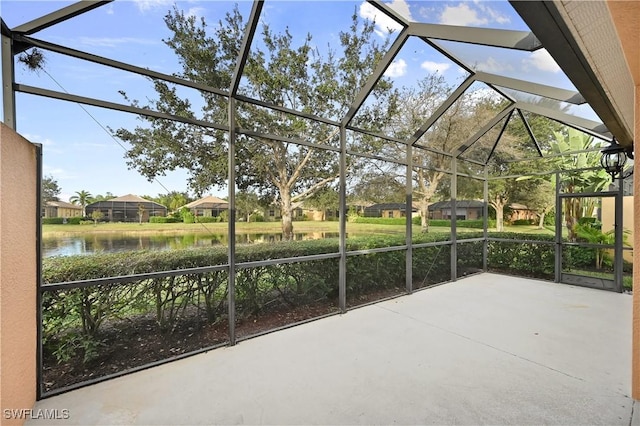 view of patio featuring a water view and a lanai