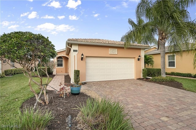 mediterranean / spanish-style house with a garage and a front lawn