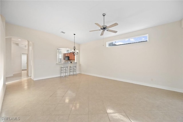 unfurnished room with light tile patterned floors, ceiling fan with notable chandelier, and vaulted ceiling