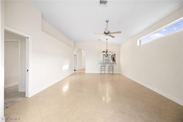 unfurnished living room with ceiling fan with notable chandelier and light tile patterned floors