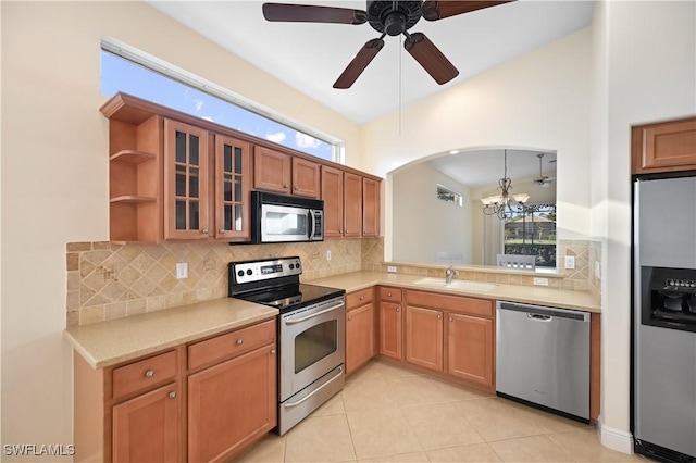 kitchen featuring light tile patterned flooring, appliances with stainless steel finishes, sink, backsplash, and hanging light fixtures