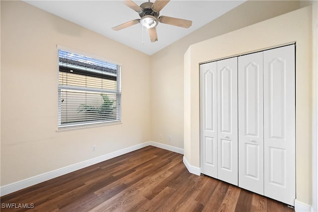 unfurnished bedroom featuring dark wood-type flooring, a closet, and ceiling fan