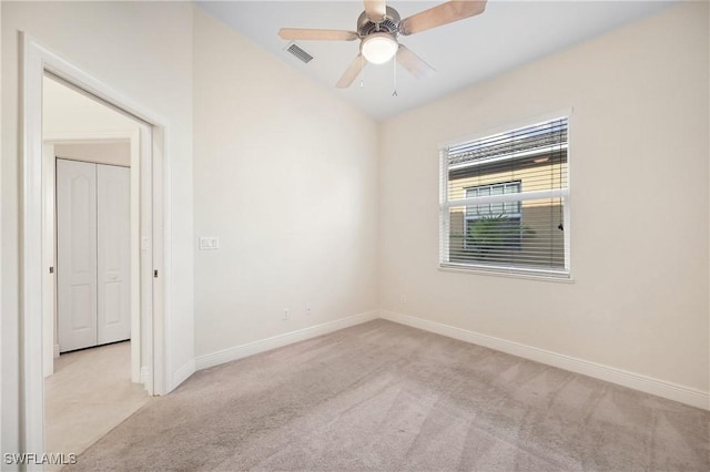 carpeted empty room featuring vaulted ceiling and ceiling fan