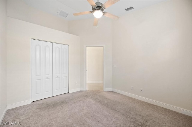 unfurnished bedroom featuring light carpet, ceiling fan, and a closet