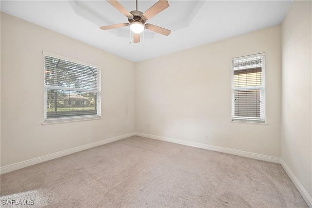 spare room with light colored carpet and ceiling fan