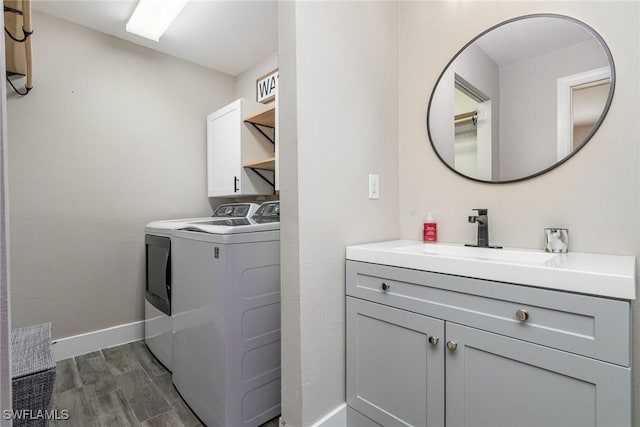 washroom with independent washer and dryer, sink, dark hardwood / wood-style floors, and cabinets