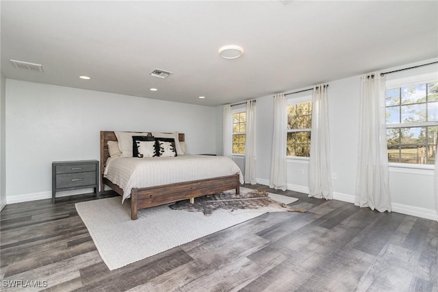 bedroom with dark wood-type flooring and multiple windows