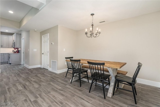 dining space featuring wood-type flooring and a notable chandelier