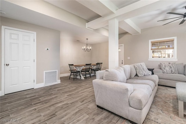 living room featuring hardwood / wood-style flooring, beam ceiling, and ceiling fan with notable chandelier