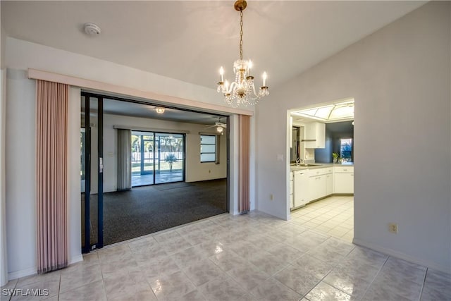 interior space featuring white cabinetry, hanging light fixtures, white dishwasher, light tile patterned flooring, and vaulted ceiling