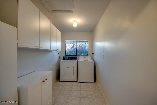 clothes washing area featuring cabinets, light tile patterned floors, and washer and dryer