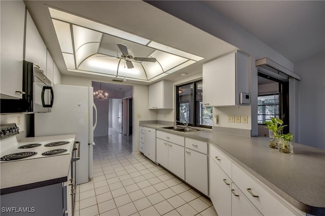 kitchen featuring white appliances, a tray ceiling, sink, and white cabinets