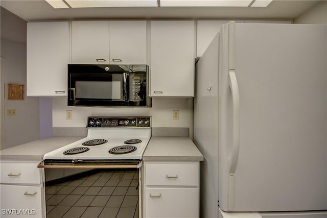 kitchen with white cabinetry, range with electric cooktop, dark tile patterned floors, and white fridge