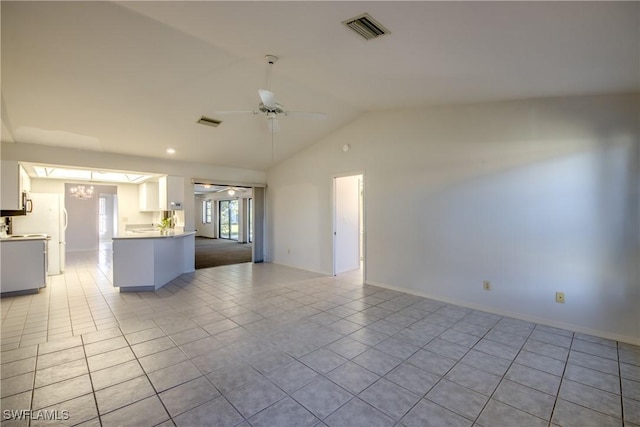 kitchen with vaulted ceiling, light tile patterned floors, ceiling fan with notable chandelier, and white cabinets